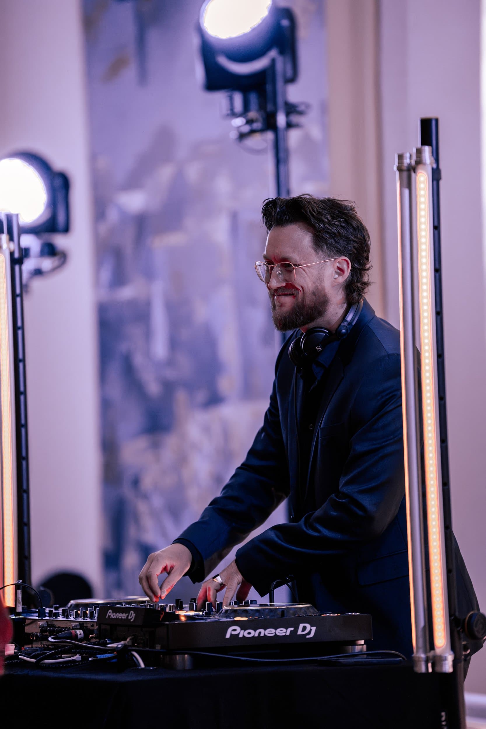 DJ i Trondheim ved en Pioneer DJ-mikser, med scenelys i bakgrunnen