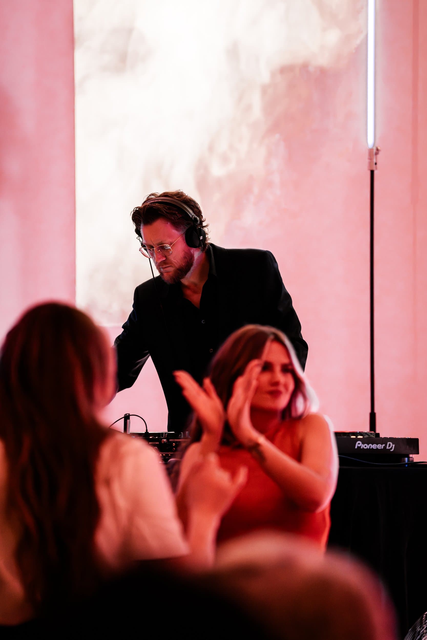 DJ i Trondheim bak mikseren med to gjester i forgrunnen på dansegulvet