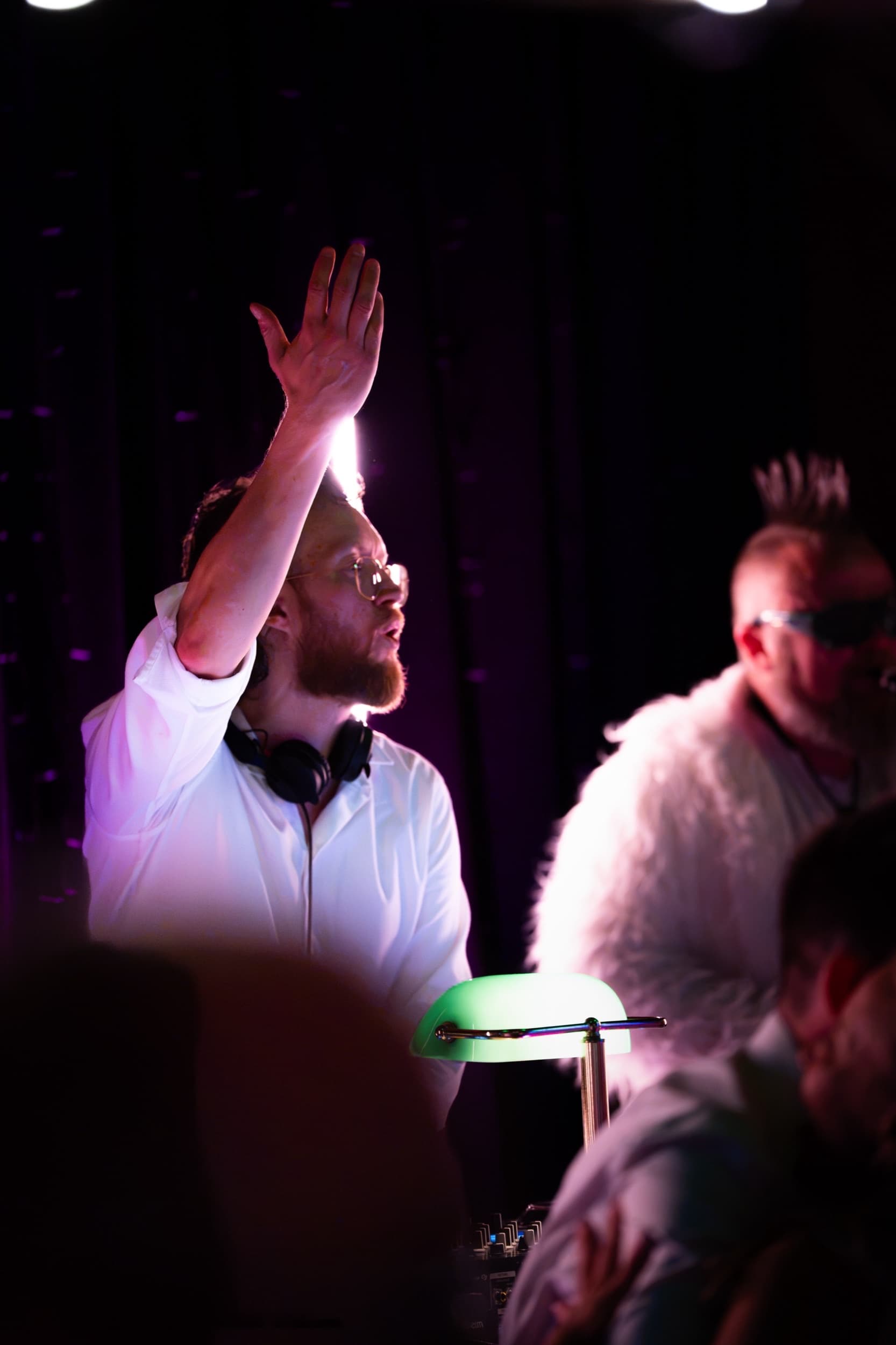 DJ i Trondheim løfter armen mens han spiller, med hodetelefoner rundt halsen