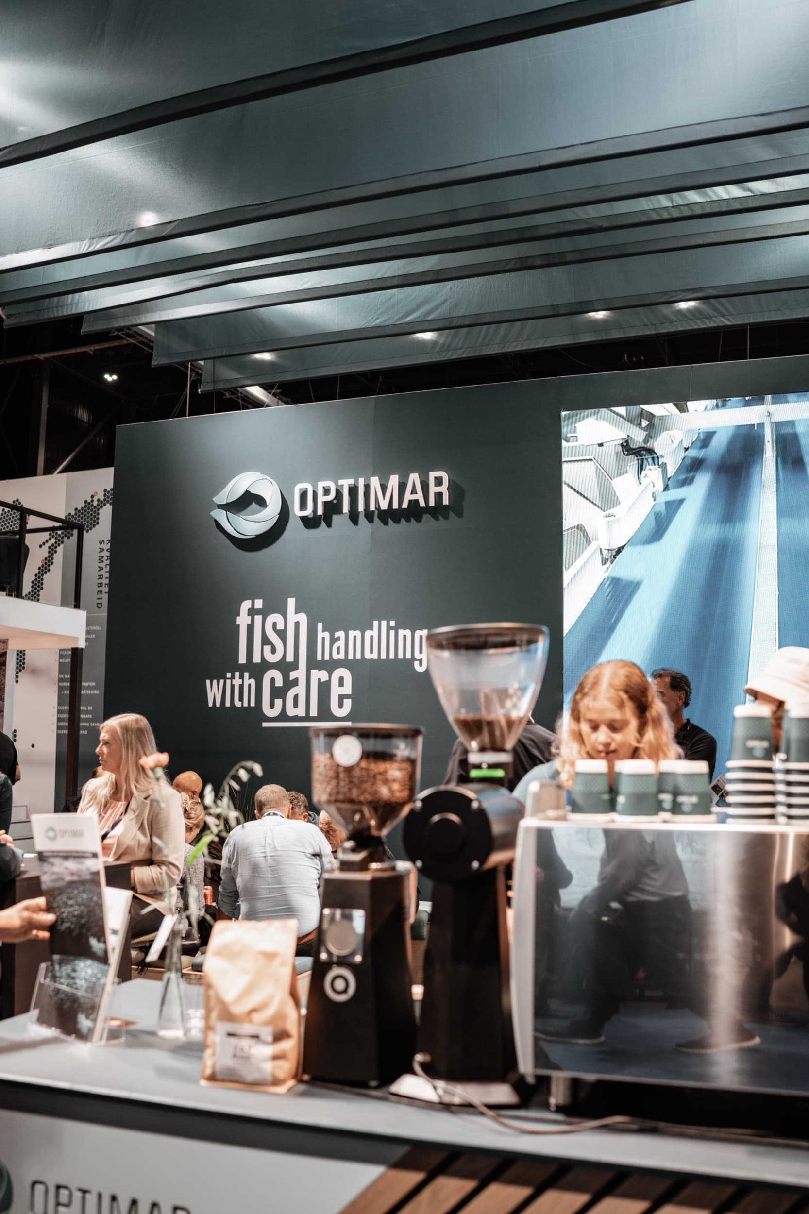 Mennesker samlet ved en kaffebar på en utstillerstand på Nor-Fishing