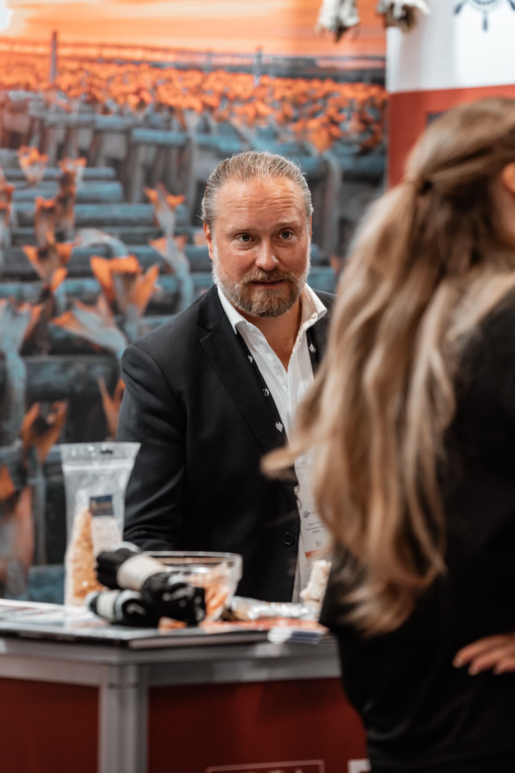 To personer i samtale ved en utstillerstand på Nor-Fishing