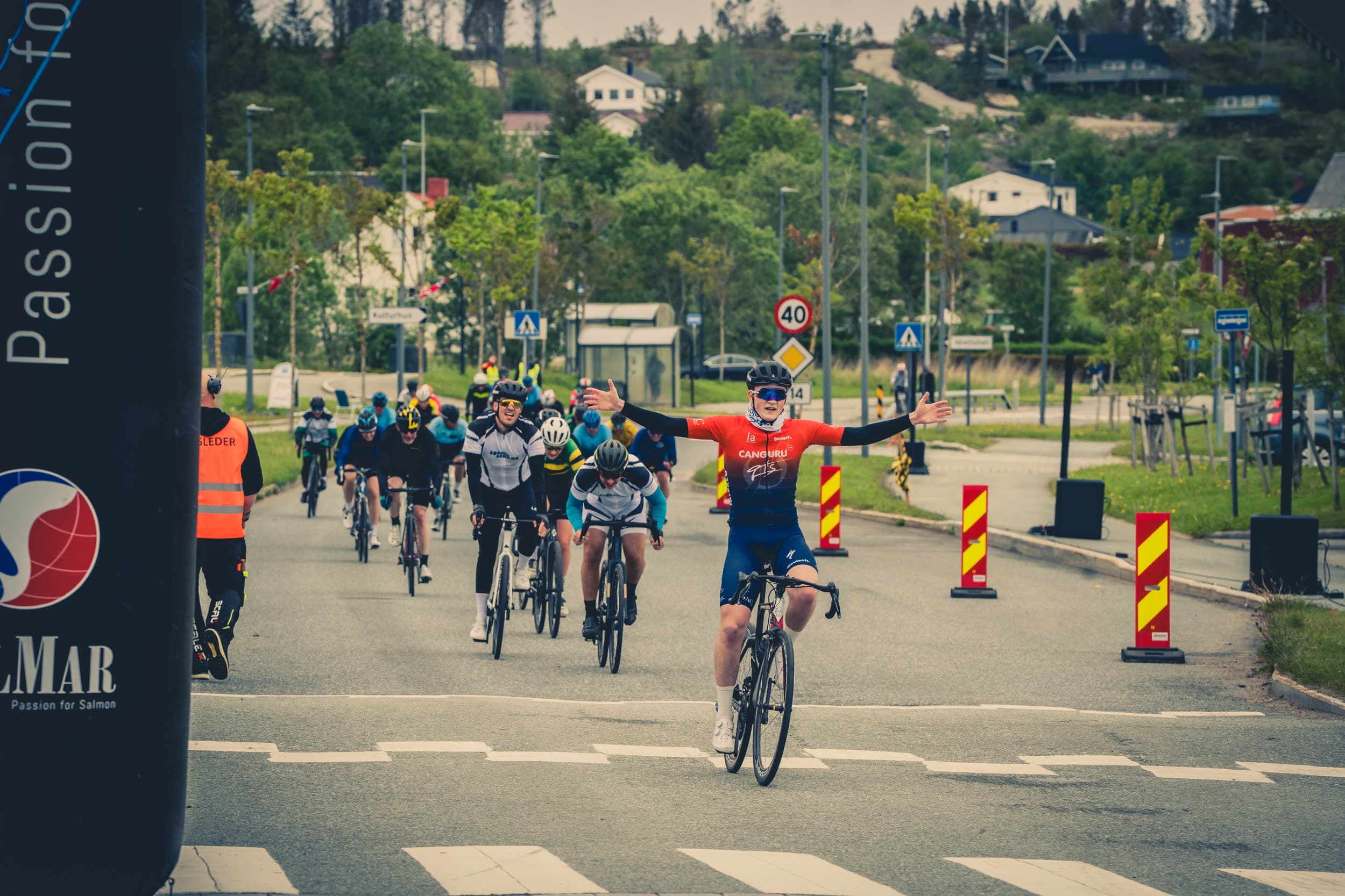 En rytter jubler med armene i været ved mållinjen til Tour de Frøya